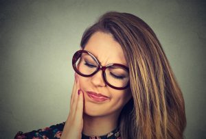 woman in glasses with sensitive toothache pain
