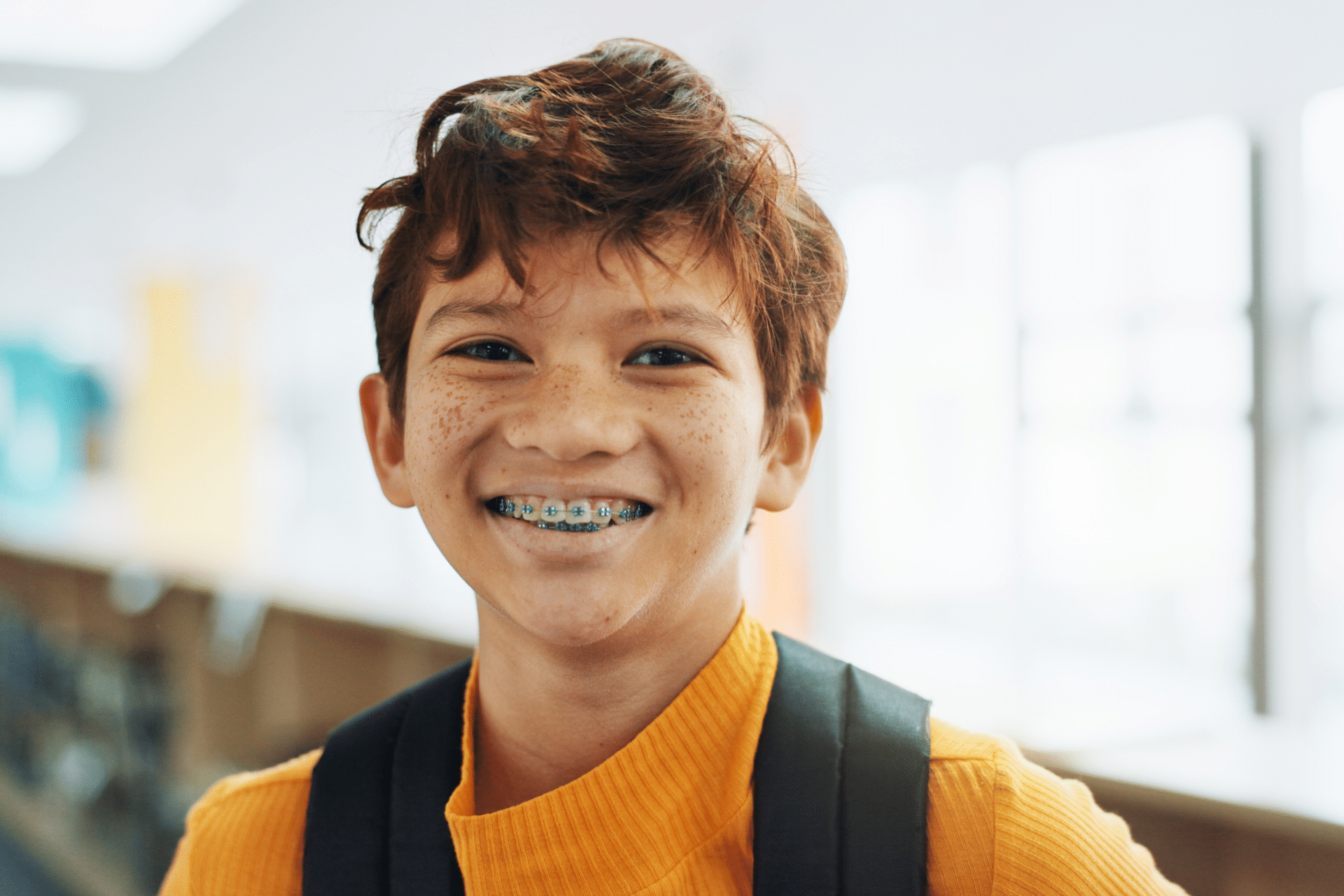 Smiling child wearing metal braces and a backpack